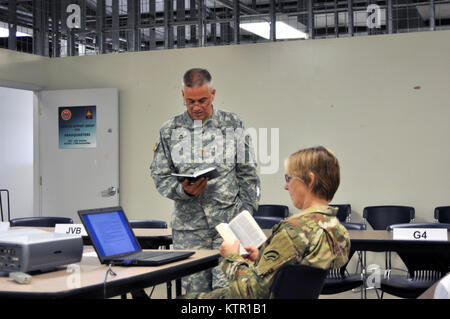 New York Army National Guard Maj. Brock, der Kaplan und Master Sgt. Linda Nosbisch, Seelsorger Assistant von der 42th Infantry Division, Troy, N.Y. lesen aus der Bibel während Dienstleistungen in Fort Polk, Louisiana, Juli 10. Mehr als 3.000 der New York Army National Guard Soldaten bereitgestellt Fort Polk, Louisiana für eine dreiwöchige Übung in der Armee Joint Readiness Training Center, July 9-30, 2016. Stockfoto