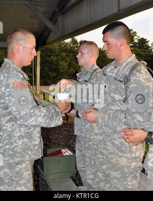 New York Army National Guard Leutnant Gregor Braun, ein Kaplan für die Konzernzentrale, 2.BATAILLON, 108 Infanterie in Utica, New York zugeordnet bietet eine Eucharistie, die Kommunion zu Spec. Michael Forschino vom Warwick fällt, N.Y. ein infanterist Det zugeordnet. 2.B, 2.BATAILLON, 108 Infanterie in Saranac Lake, während der Gottesdienste an Ft. Polk, La am 13. Juli. Mehr als 3.000 der New York Army National Guard Soldaten bereitgestellt Fort Polk, Louisiana für eine dreiwöchige Übung in der Armee Joint Readiness Training Center, July 9-30, 2016. Die militärgeistlichen sind verantwortlich für die Pflege der religi Stockfoto