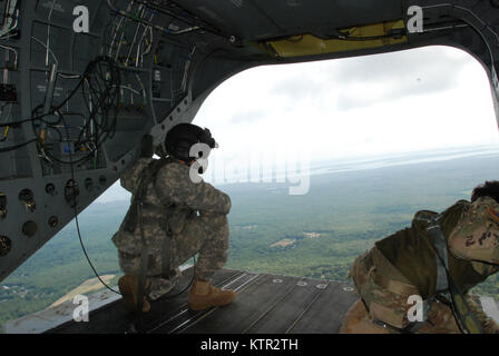 New York Army National Guard Crew Chief Sgt. 1. Klasse Stan Bagrowski (links) blickt von einem CH-47 Chinook Hubschrauber F von der New York Army National Guard Co. B 3 Bataillon 126 Luftfahrt Leapfest 2016 Betrieben an der Universität von Rhode Island, West Kingston, R.I., August 6, 2016. Leapfest ist der größte und am längsten bestehende, internationale statische Linie Fallschirm Training und Wettbewerb veranstaltet vom 56. Truppe den Befehl, Rhode-Island Army National Guard hohe technische Ausbildung zu fördern und Korpsgeist innerhalb der internationalen Gemeinschaft in der Luft. Der New York Army Nat Stockfoto