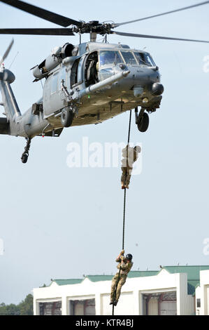 WESTHAMPTON BEACH, NY-Pararescuemen aus der 103 Rescue Squadron und das Bodenpersonal von Die 101 Rescue Squadron ein Personal recovery Demonstration am FS Gabreski Air National Guard Base Verhalten am 10. September 2016. Die Ausbildung nahm Teil während der Tag der Familie, und beteiligt sich Pararescuemen fastroping aus ein HH-60 Pavehawk, Wiederherstellung eines abgestürzten Personal simuliert, dann mit Hilfe einer Strickleiter zum Flugzeug zu kommen. Sowohl die 101 RQ und 103 RQS gehören zu den 106 Rettung Flügel. (US Air National Guard/Staff Sergeant Christopher S. Muncy/freigegeben) Stockfoto