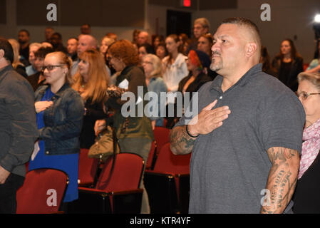 Familie Mitglieder stehen für das Abspielen der Nationalhymne während der 107 Militärpolizei Unternehmen Bereitstellung Zeremonie, Brooklyn, N.Y., Sept. 29, 2016. Die 29 New York National Guard Soldaten Bildungsurlaub in Fort Bliss, Texas, bevor sie nach Afghanistan zur Unterstützung der Operation, die die Freiheit des Sentinel. Stockfoto