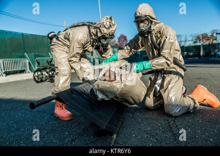 Soldaten in die 222Nd Chemical Company, New York Army National Guard, und Offiziere mit COBRA der New Yorker Polizei (chemische, biologische und radiologische Bewusstsein) Training Unit eine Übung führen Sie die Simulation eines städtischen chemischen Angriff bei rodman's Hals taktische Dorf, Bronx, New York, November 19, 2016 zugeordnet. Der New York Army National Guard Soldaten und Offiziere mit der COBRA training Einheit, in der die Übung Techniken und Verfahren zu teilen, sowie ihre Bereitschaft, im Falle einer Naturkatastrophe oder Terroranschlag zu verbessern. (U.S. Army National Guard Foto von Sgt. Harley Stockfoto