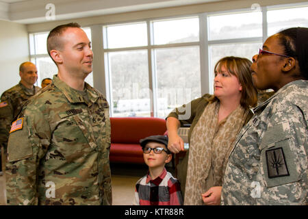 Staff Sgt. Michael Davis, 138 Öffentliche Angelegenheiten Loslösung, wird gefördert und von seiner Frau Megan Davis im Camp Smith, N.Y., Dez. 4, 2016 festgesteckt. (U.S. Army National Guard Foto von Sgt. Harley Jelis) Stockfoto