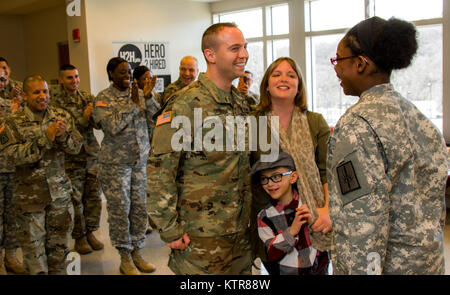 Staff Sgt. Michael Davis, 138 Öffentliche Angelegenheiten Loslösung, wird gefördert und von seiner Frau Megan Davis im Camp Smith, N.Y., Dez. 4, 2016 festgesteckt. (U.S. Army National Guard Foto von Sgt. Harley Jelis) Stockfoto