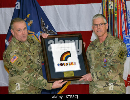 LATHAM, N.Y.-- Brig. Gen. Gary Yaple, stellvertretender Kommandeur (Operations) der 42th Infantry Division der New York Army National Guard (links), und Chief Warrant Officer 5 Robert Wold, die ausgehende Befehl Chief Warrant Officer der New York Army National Guard (rechts), stellen mit einer Plakette der Division Wold beim Wechsel gab der Behörde Festakt in New York National Guard Sitz hier am 9. Chief Warrant Officer 4 Jeffrey Schirmer übernahm Chief Warrant Officer Aufgaben während der Zeremonie. Schirmer, ein Leicester N.Y. Bewohner und ein Veteran von zwei Kriege, ist verantwortlich für die r Stockfoto