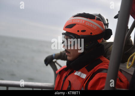 HAMPTON BAYS, NY-Flieger mit 101 Rescue Squadron und 103 Rescue Squadron Verhalten hoist Training mit United States Coastguardsmen von US Coast Guard Station Shinnecock zum 22. Dezember 2016. Während dieser Ausbildung, die Schutzengel aus der 103 RQS wurden über Hoist aus ein HH-60 Pavehawk auf das Deck des Schneidwerk abgesenkt. Danach wird das Flugzeug praktiziert Fallenlassen und Entfernen patient Würfe, vor dem Heben der Schutzengel sichern und für die Rückkehr zum Ausgangspunkt. (US Air National Guard/Staff Sergeant Christopher S. Muncy/freigegeben) Stockfoto