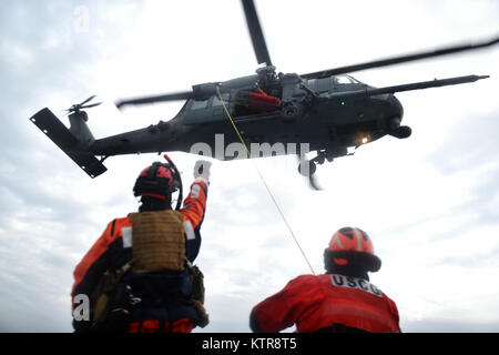 HAMPTON BAYS, NY-Flieger mit 101 Rescue Squadron und 103 Rescue Squadron Verhalten hoist Training mit United States Coastguardsmen von US Coast Guard Station Shinnecock zum 22. Dezember 2016. Während dieser Ausbildung, die Schutzengel aus der 103 RQS wurden über Hoist aus ein HH-60 Pavehawk auf das Deck des Schneidwerk abgesenkt. Danach wird das Flugzeug praktiziert Fallenlassen und Entfernen patient Würfe, vor dem Heben der Schutzengel sichern und für die Rückkehr zum Ausgangspunkt. (US Air National Guard/Staff Sergeant Christopher S. Muncy/freigegeben) Stockfoto