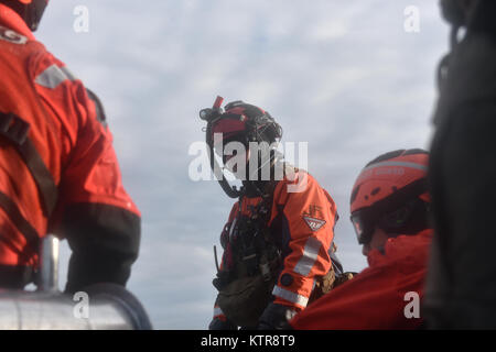 HAMPTON BAYS, NY-Flieger mit 101 Rescue Squadron und 103 Rescue Squadron Verhalten hoist Training mit United States Coastguardsmen von US Coast Guard Station Shinnecock zum 22. Dezember 2016. Während dieser Ausbildung, die Schutzengel aus der 103 RQS wurden über Hoist aus ein HH-60 Pavehawk auf das Deck des Schneidwerk abgesenkt. Danach wird das Flugzeug praktiziert Fallenlassen und Entfernen patient Würfe, vor dem Heben der Schutzengel sichern und für die Rückkehr zum Ausgangspunkt. (US Air National Guard/Staff Sergeant Christopher S. Muncy/freigegeben) Stockfoto