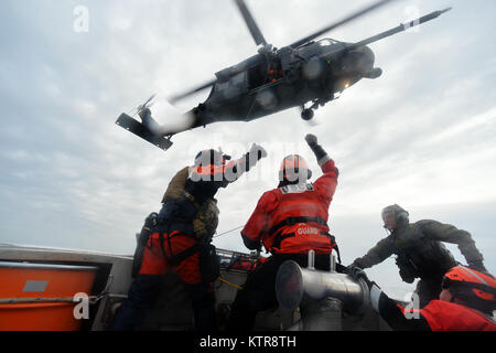 HAMPTON BAYS, NY-Flieger mit 101 Rescue Squadron und 103 Rescue Squadron Verhalten hoist Training mit United States Coastguardsmen von US Coast Guard Station Shinnecock zum 22. Dezember 2016. Während dieser Ausbildung, die Schutzengel aus der 103 RQS wurden über Hoist aus ein HH-60 Pavehawk auf das Deck des Schneidwerk abgesenkt. Danach wird das Flugzeug praktiziert Fallenlassen und Entfernen patient Würfe, vor dem Heben der Schutzengel sichern und für die Rückkehr zum Ausgangspunkt. (US Air National Guard/Staff Sergeant Christopher S. Muncy/freigegeben) Stockfoto