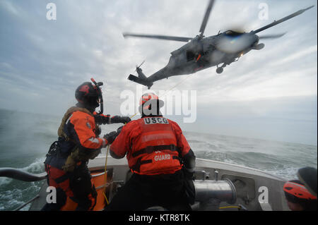 HAMPTON BAYS, NY-Flieger mit 101 Rescue Squadron und 103 Rescue Squadron Verhalten hoist Training mit United States Coastguardsmen von US Coast Guard Station Shinnecock zum 22. Dezember 2016. Während dieser Ausbildung, die Schutzengel aus der 103 RQS wurden über Hoist aus ein HH-60 Pavehawk auf das Deck des Schneidwerk abgesenkt. Danach wird das Flugzeug praktiziert Fallenlassen und Entfernen patient Würfe, vor dem Heben der Schutzengel sichern und für die Rückkehr zum Ausgangspunkt. (US Air National Guard/Staff Sergeant Christopher S. Muncy/freigegeben) Stockfoto