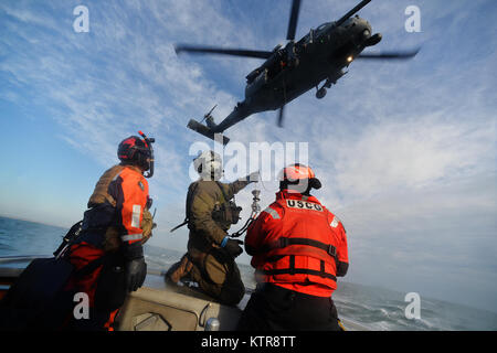 HAMPTON BAYS, NY-Flieger mit 101 Rescue Squadron und 103 Rescue Squadron Verhalten hoist Training mit United States Coastguardsmen von US Coast Guard Station Shinnecock zum 22. Dezember 2016. Während dieser Ausbildung, die Schutzengel aus der 103 RQS wurden über Hoist aus ein HH-60 Pavehawk auf das Deck des Schneidwerk abgesenkt. Danach wird das Flugzeug praktiziert Fallenlassen und Entfernen patient Würfe, vor dem Heben der Schutzengel sichern und für die Rückkehr zum Ausgangspunkt. (US Air National Guard/Staff Sergeant Christopher S. Muncy/freigegeben) Stockfoto