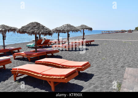 Sonnenschirme und Yachten in Perissa, Santorini, Griechenland Stockfoto