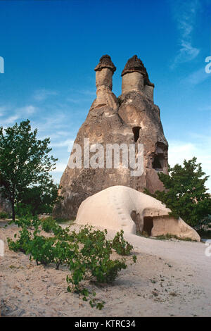 Eine vulkanische Fairy Chimney oder Hoodoo geschnitzt aus weichem verwitterten Tuff oder Vulkangestein in Pasabag Tal, in der Nähe von Zelve, Nevsehir, Kappadokien, Türkei. Der Fels Kegel mit einem Felsen geschnitzt, höhlenwohnungen Wohnung, der Einsiedler Rückzug und Kapelle Saint Simeon oder Simon.. Stockfoto