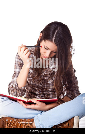 Schöne weibliche Studenten studieren auf dem Boden isoliert auf weißem Hintergrund Stockfoto