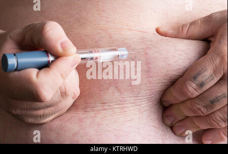 Insulin wird über einem Insulinpen in große mans Magen verabreicht. Stockfoto