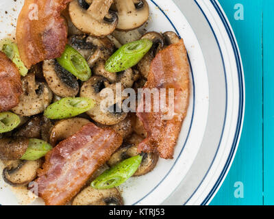 Speck, Pilzen und Frühlingszwiebeln auf Toast Frühstück Essen Stockfoto