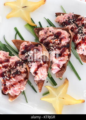 Thunfisch tostadas - rohen Thunfisch Bits auf tostada Chips mit sternfrucht und Gurke schälen eingerichtet - eine Verschmelzung von japanischen und mexikanischen Küche. Stockfoto