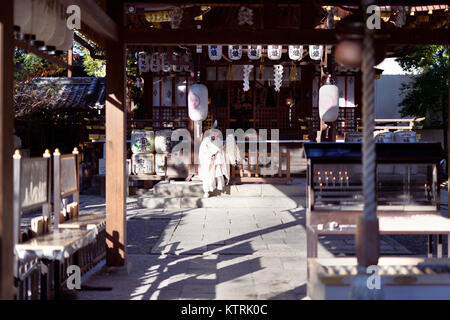 Kannushi Priester an yasui Konpira-gu, yasui Konpiragu Shinto Schrein mit Suzu Bell im Vordergrund. Gion Distrikt, Kyoto, Japan 2017. Stockfoto