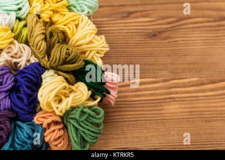 Bunte stricken Threads auf einem Holz- Hintergrund. Stockfoto