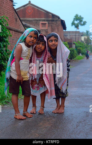 Kinder stehen und sich selbst schützen mit einem Handtuch von Regen Stockfoto