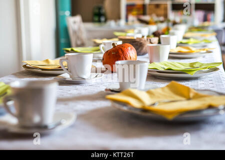 Schönen festlichen Tisch bunt Gelb Herbst helloween Kürbis Deko Kaffeetassen mit untertassen Teller und Löffel Stockfoto