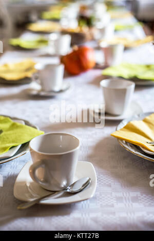 Schönen festlichen Tisch bunt Gelb Herbst helloween Kürbis Deko Kaffeetassen mit untertassen Teller und Löffel Stockfoto