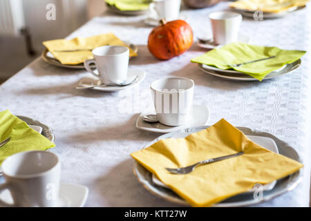 Schönen festlichen Tisch bunt Gelb Herbst helloween Kürbis Deko Kaffeetassen mit untertassen Teller und Löffel Stockfoto