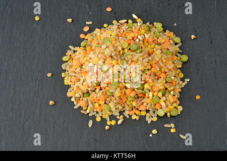 Haufen von rohem Getreide und Hülsenfrüchte auf einer Schiefertafel Platte, von oben Stockfoto