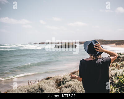 Frau am Strand mit Hut, Twelve Apostles, Twelve Apostles Marine National Park, Victoria, Australien Stockfoto