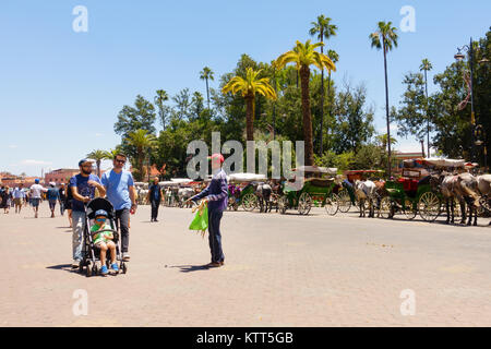 Marrakesch, Marokko - Mai 12, 2017: Marokkaner Verkauf von Waren an Touristen auf der Straße in Richtung Jemaa el Fna in Marrakesch während Pferd dr Stockfoto