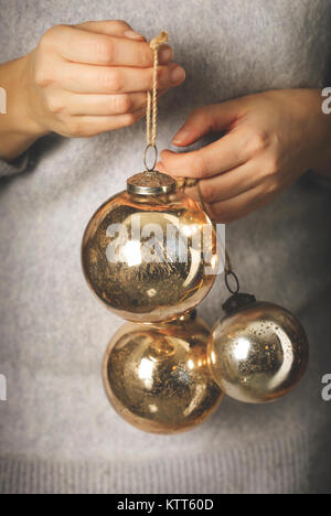 Frau mit goldenen Christbaumkugeln Stockfoto