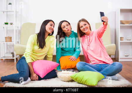 Drei Freunde sitzen im Zimmer und unter selfie. Stockfoto