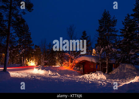 Winter Nacht. Auto camping im Wald. Viel Schnee. Weihnachten Girlanden und Spuren der Scheinwerfer Stockfoto