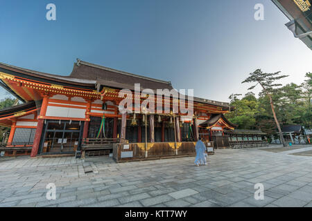 Buddhistischer Priester gehen an Honden (Große Halle) Japan wichtiges kulturelles Eigentum von Yasaka Shinto Schrein. Am frühen Morgen. Kyoto, Japan Stockfoto