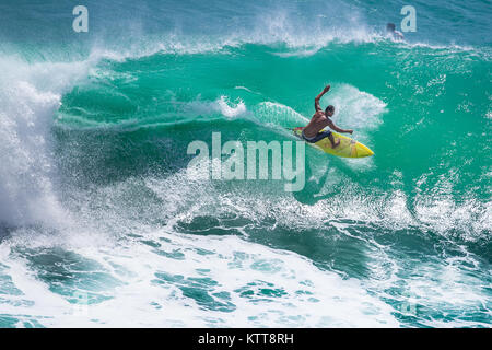 Surfer reiten große grüne Welle in Padang Padang Strand, Bali, Indonesien Stockfoto