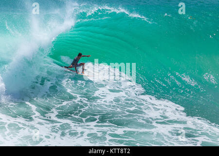 Surfer reiten große grüne Welle in Padang Padang Strand, Bali, Indonesien Stockfoto