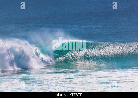 Surfer reiten große grüne Welle bei Uluwatu Strand, Bali, Indonesien Stockfoto