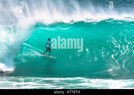 Surfer reiten große grüne Welle in Padang Padang Strand, Bali, Indonesien Stockfoto