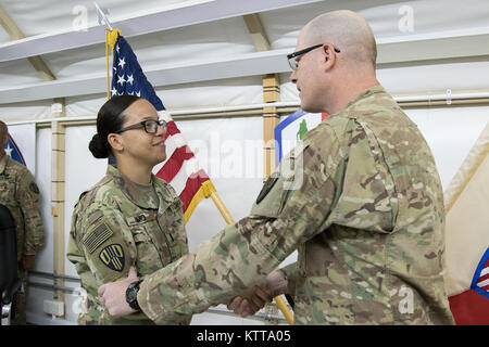 Melissa Simo, ein Brooklyn Bewohner, wird in den Rang eines 1st Lieutenant von Oberst Stephen Bousquet, 369 Sustainment Brigade Commander, während einer Zeremonie im Camp Arifjan, Kuwait, 24. April 2017 gefördert. Simo ist nach Kuwait, implementiert mit der 369 Sustainment Brigade, bekannt als der "Harlem Hölle Kämpfer", und in diesem Sommer erneut bereitstellen. (U.S. Armee Foto von Sgt. Cesar Leon) Stockfoto