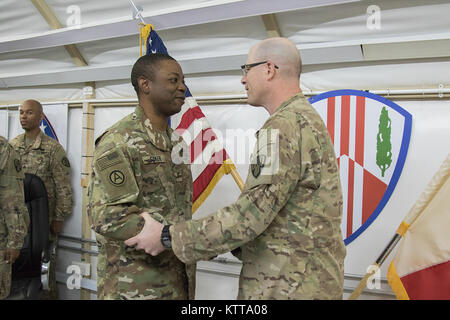 Christopher Coker, ein Brooklyn Bewohner, ist von Oberst Stephen Bousquet, 369 Sustainment Brigade Commander, während einer Zeremonie im Camp Arifjan, Kuwait, 24. April 2017 in den Rang eines Chief Warrant Officer 3 gefördert. Coker ist nach Kuwait, implementiert mit der 369 Sustainment Brigade, bekannt als der "Harlem Hölle Kämpfer", und in diesem Sommer erneut bereitstellen. (U.S. Armee Foto von Sgt. Cesar Leon) Stockfoto