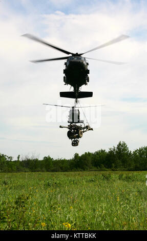 FORT DRUM, NEW YORK - Zwei UH-60 Blackhawk Hubschrauber aus der 42 Combat Aviation Brigade transportiert zwei M 119 2 Haubitzen auf eine Landing Zone während einer Air Assault Artillerie raid Hier Juni 9. Die raid, die in Verbindung mit Soldaten aus Alpha Truppe, 1st Battalion, 258Th Field Artillery Regiment, 27 Infantry Brigade Combat Team durchgeführt wurde, beteiligten Transport der 4 Haubitzen auf eine Landing Zone dann nutzen Sie eine simulierte feindliches Ziel zu engagieren. (U.S. Army National Guard Foto von Sgt. Alexander Rektor) Stockfoto