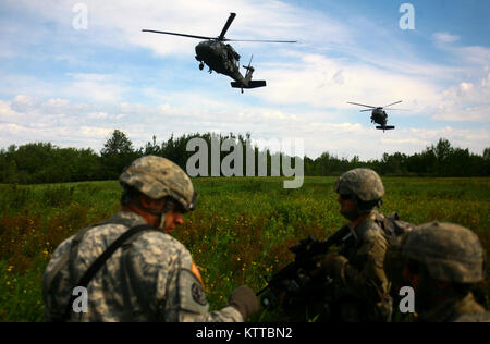 FORT DRUM, New York - New York Army National Guard Soldaten zu Alpha Batterie, 1st Battalion, 258Th Field Artillery Regiment, 27 Infantry Brigade Combat Team zugewiesen erwarten Extraktion durch zwei 3. Bataillon, 142 Aviation UH-60 Blackhawks während einer Air Assault Artillerie Bohrer an Fort Drum am 9. Juni 2017. Während der Raid die Artillerie Soldaten und ihre haubitzen auf eine Landing Zone geflogen waren und verwendet eine simulierte feindliches Ziel zu engagieren. (U.S. Army National Guard Foto von Sgt. Alexander Rektor) Stockfoto