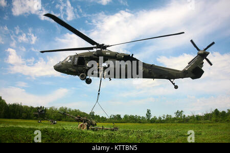 FORT DRUM, NEW YORK - EIN UH-60 Blackhawk Hubschrauber vom 3 Bataillon der New York Army National Guard, 142 Aviation Regiment, Transporte, ein M119A2 howitzer während einer Air Assault Artillerie raid am Fort Drum am 9. Juni 2017. Die raid, in Zusammenarbeit mit den 27 IBCT 258th Field Artillery Regiment beteiligt Transport 4 Haubitzen der Einheit auf eine Landing Zone, wo Sie dann benutzt wurden, eine simulierte feindliches Ziel zu engagieren. (U.S. Army National Guard Foto von Sgt. Alexander Rektor) Stockfoto