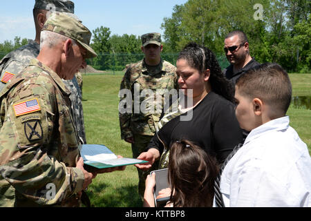 New York Army National Guard Soldat, Command Sgt. Maj. Joseph Marino präsentiert eine Medaille und eine Urkunde zu der Familie der Master Sgt. Rudolph Seabron während einer Trauerfeier in seiner Ehre am Joint Force Headquarters, Latham, N.Y., 10. Juni 2017. Master Sgt. Rudolph Seabron verstarb im Januar 2017. (U.S. Army National Guard Foto von Pfc-Andrew Valenza) Stockfoto