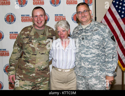 Us-Armee Kapitän John Härter, stellvertretender Stabschef für Personal für die 53 Truppe den Befehl, der New York Army National Guard, wirft mit seiner Mutter und seinem Befehl Sgt. Maj. Landy, Senior Advisor für die NY Army National Guard zivilen Support Team, während seiner Promotion Zeremonie im Camp Smith Training Website zum 30. Juni 2017 eingetragen. (U.S. Army National Guard Foto: Staff Sgt. Danny Martinez) Stockfoto