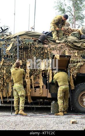 SHOALWATER BAY, AU-Soldaten in den 1 Signal Regiment, Australian Defence Force zugewiesen, befestigen Sie Geräte an einen Australischen geschützt Mobilität Fahrzeug während der Vorbereitung für übung Talisman Sabre, Juli 10. Während der Übung der australischen Streitkräfte Personal wird Ihre Kampftechniken neben USA und Neuseeland service Mitglieder schärfen. (U.S. Army National Guard Foto von Sgt. Alexander Rektor) Stockfoto