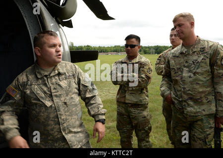 New York Army National Guard Soldat, Sgt. Shawn Bradley, ein Mannschaft Leiter mit 3.BATAILLON, 142 Luftfahrt, beauftragt Active Duty Soldaten aus Bravo Batterie 2 Bataillon, 15 Field Artillery Regiment, 2nd Brigade Combat Team, auf, wie man ein Black Hawk für die artillerie Razzien in Fort Drum, N.Y., 13. Juli 2017 ein. Nationalgarde und aktive Aufgabe Soldaten arbeiteten gemeinsam für diese Schulung auf andere Missionen in der ganzen Woche. (U.S. Army National Guard Foto von Pfc. Andrew Valenza) Stockfoto