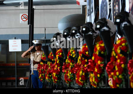 Ein U.S. Marine Corps bugle Player begrüßt nach dem Spiel tippt während einer Trauerfeier am Stewart Air National Guard Base, Newburgh, New York, Aug 27., 2017. Hunderte von Marines, Flieger und Zivilisten kamen die neun Marines Marine Antenne Refueler Transport Squadron 452 zugeordnet, die unter den 16 Toten waren nach einem KC-130 T Super Hercules Absturz im Juli zu Ehren. (U.S. Air Force Foto: Staff Sgt. Julio A. Olivencia jr.) Stockfoto