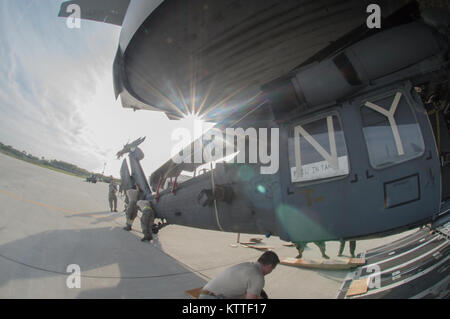 Flieger ein HH-60 Pave Hawk Hubschrauber entladen von der Rückseite eines C-17 Globemaster III. 106 Rettung der New York Air National Guard Flügel kehrt nach Hause zurück von einem Einsatz nach San Juan, Puerto Rico am 12. September, 2017. Sie waren die Luftbrücke und Rettungseinsätze in der Karibik in Reaktion auf die Verwüstung durch den Hurrikan Irma verursacht. Stockfoto