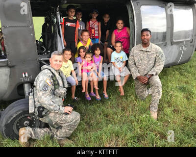 New York Army National Guard Soldaten zum 3. Bataillon 142 Assault Helicopter Bataillon zugeordnet, einige Freunde in Puerto Rico nach der Auslieferung der Hilfe am Okt. 1, 2017. Das Bataillon gesendet 60 Soldaten und 4 UH-60 s zu den Puerto Rico National Guard assit bei der Reaktion auf die Folgen des Hurrikans Maria. Stockfoto